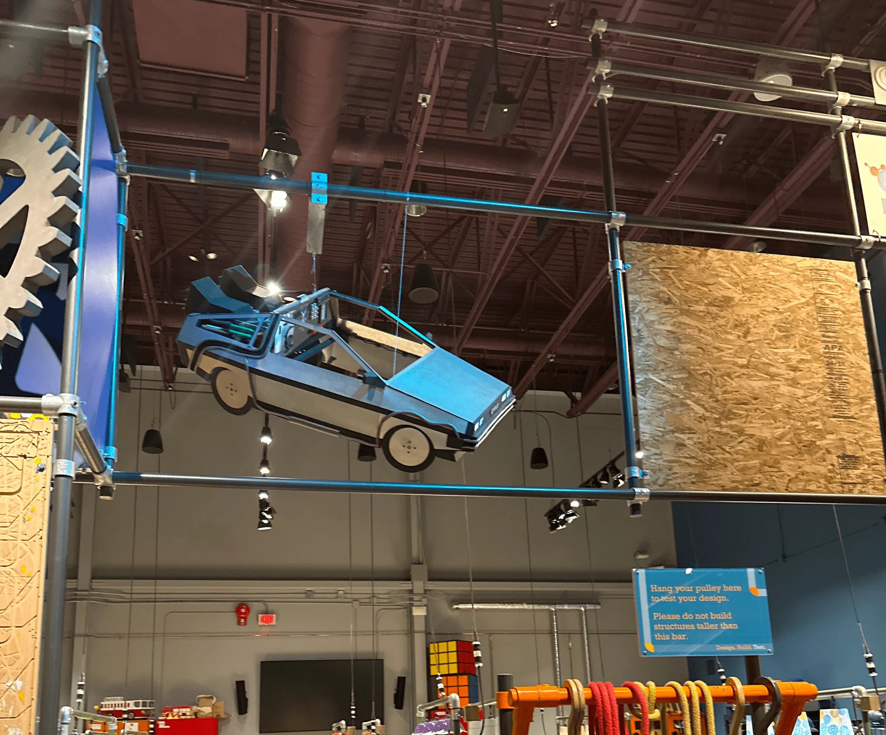 View inside the Science Garage maker-space area, featuring a hanging prototype car model suspended overhead.